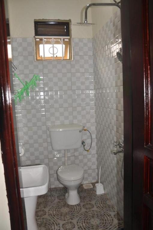a small bathroom with a toilet and a sink at PinkView Residence in Nairobi