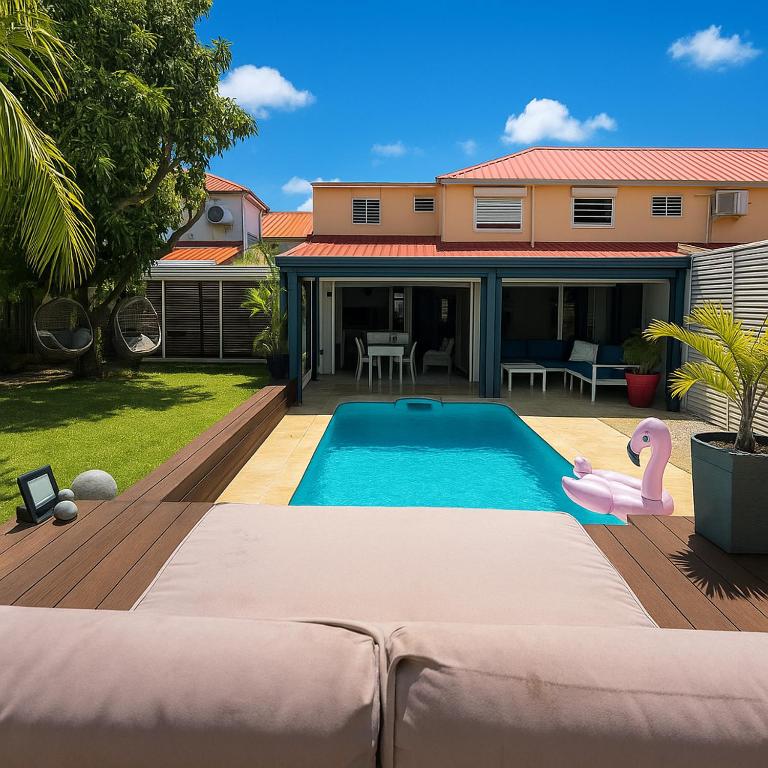a swimming pool with a pink flamingo in a backyard at Villa Tropiraizet in Les Abymes