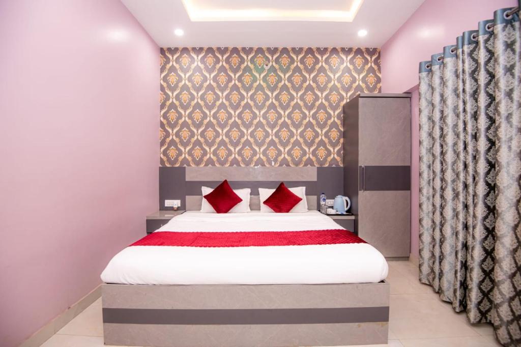 a bedroom with a large bed with red pillows at Hotel Ayodhya Palace - 400 Mtrs from HANUMAN GARHI in Ayodhya