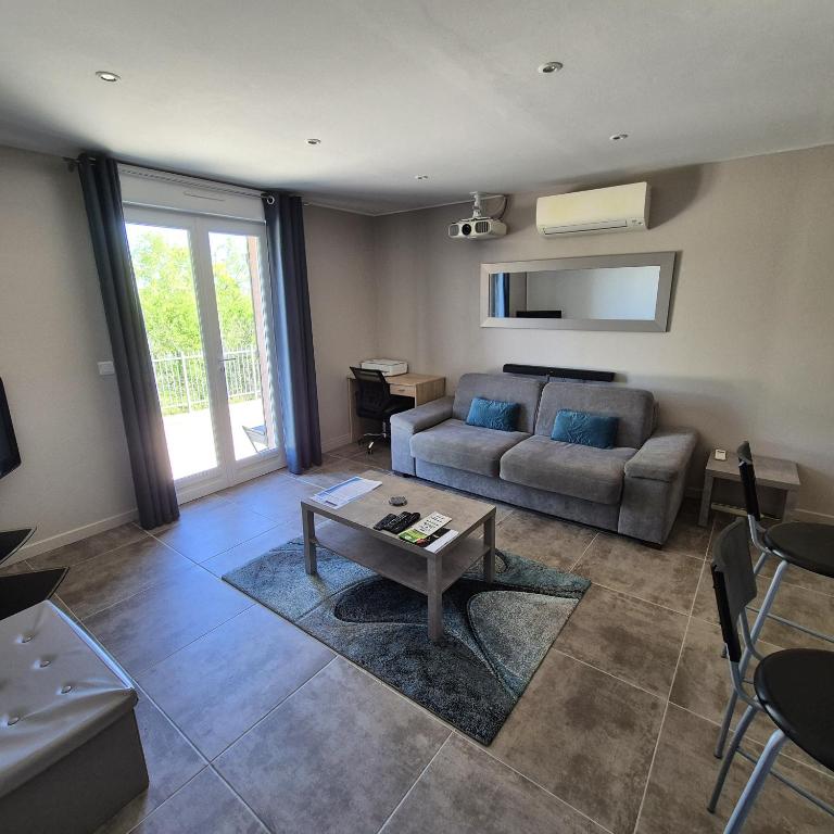 un salon avec un canapé et une table dans l'établissement Saint-Jeannet Studio apartment near Nice, à Saint-Jeannet