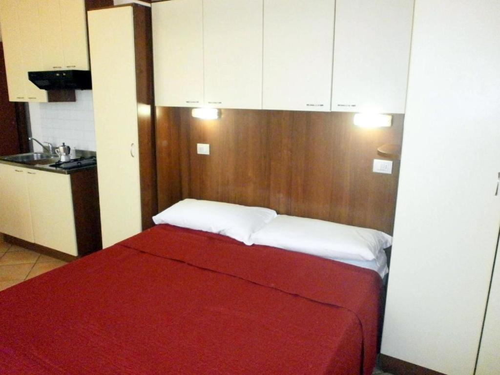 a bedroom with a red bed with white pillows at Residence Carioca in Rimini