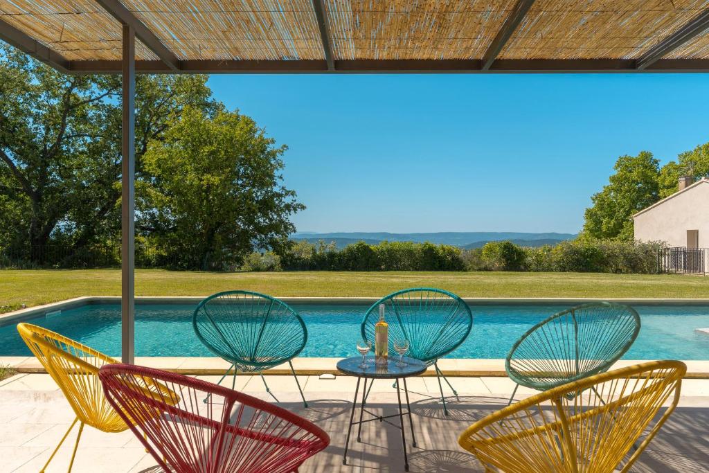 a patio with chairs and a table and a pool at La Déboulière in Cucuron
