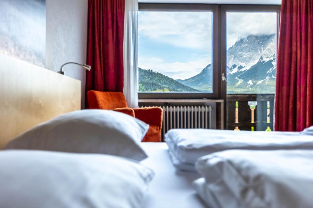a hotel room with two beds and a window at keyone rooms Loisach in Lermoos
