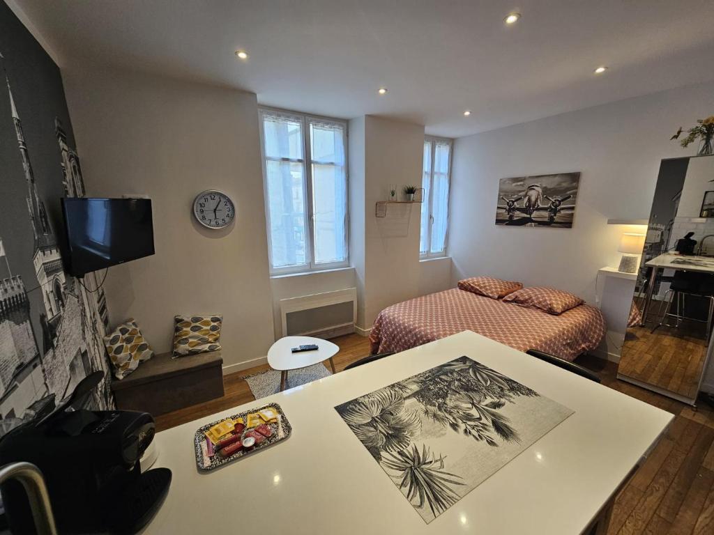 un petit salon avec un lit et une table dans l'établissement Le Pastel - grand studio rénové, à Angoulême