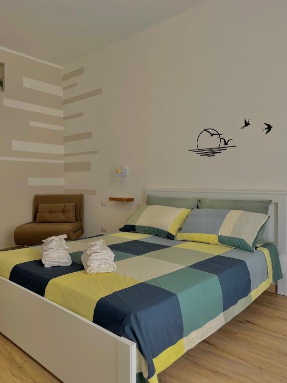 a bedroom with a large bed and a chair at Dimora Chiarina in Mola di Bari