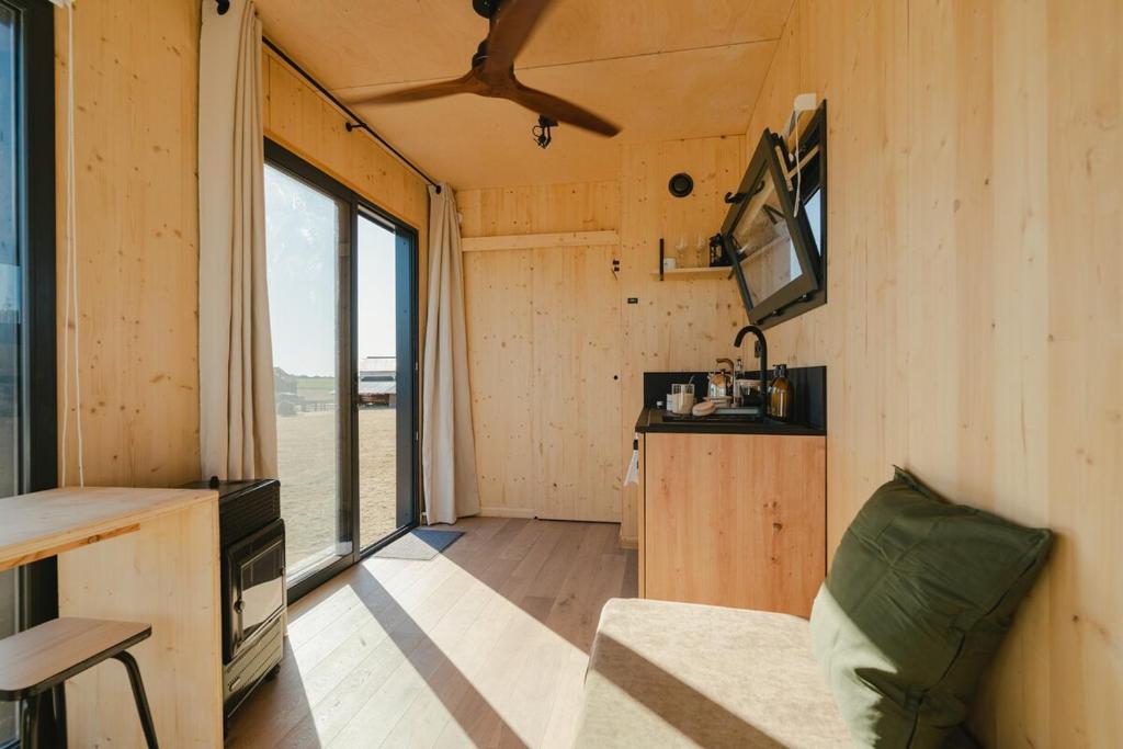Cette petite maison comprend une cuisine et un salon. dans l'établissement Parcel Tiny House Brosse 1, pleine nature proche de Sancerre, à La Celle-sous-Gouzon