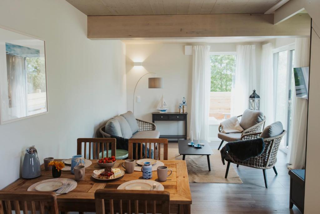 a living room with a table and chairs at NEU "Rügen Resørt Sagard" großzügige, gemütliche Doppelhaushälfte "Dag" mit Terrasse in Sagard