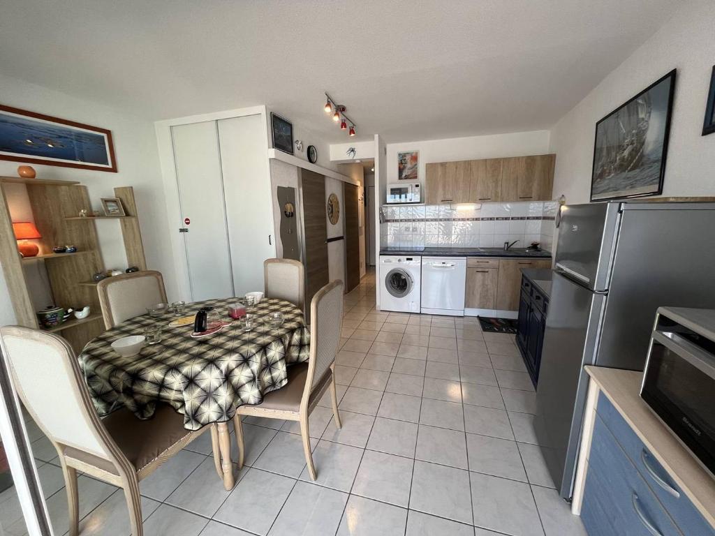 Il dispose d'une cuisine avec une table et des chaises. dans l'établissement Apt 2 pièces CAP D'AGDE NATURISME CN080-104, au Cap d'Agde