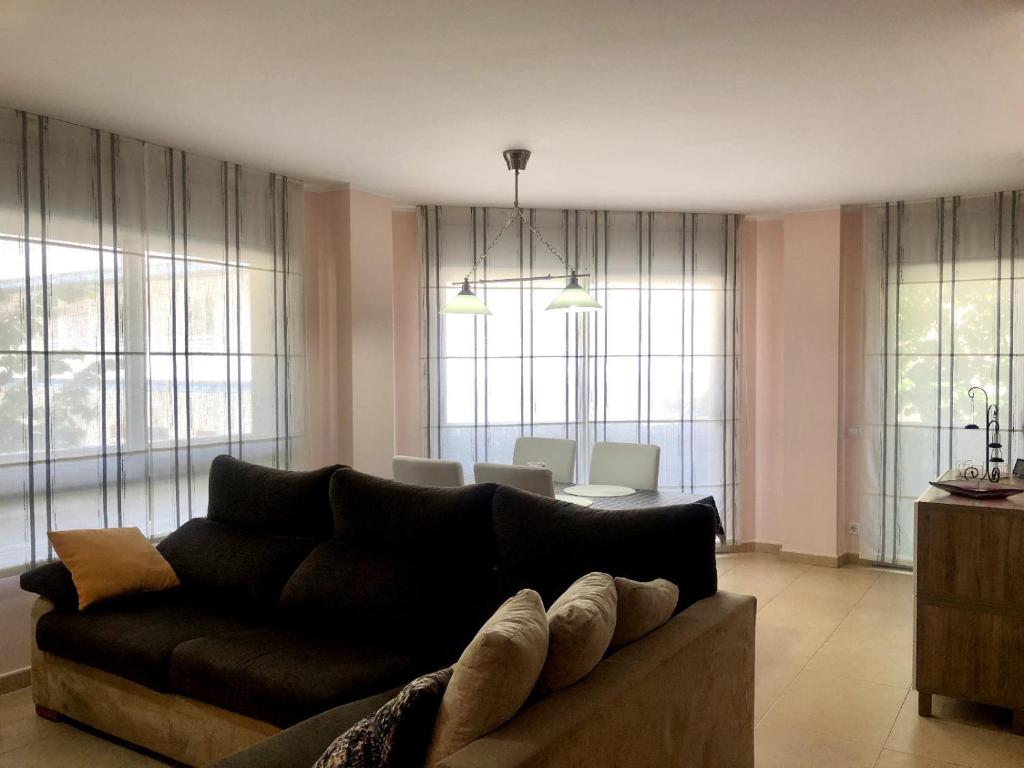 a living room with a couch and a dining room at Vivalidays - Estrella de Mar - Calella in Calella