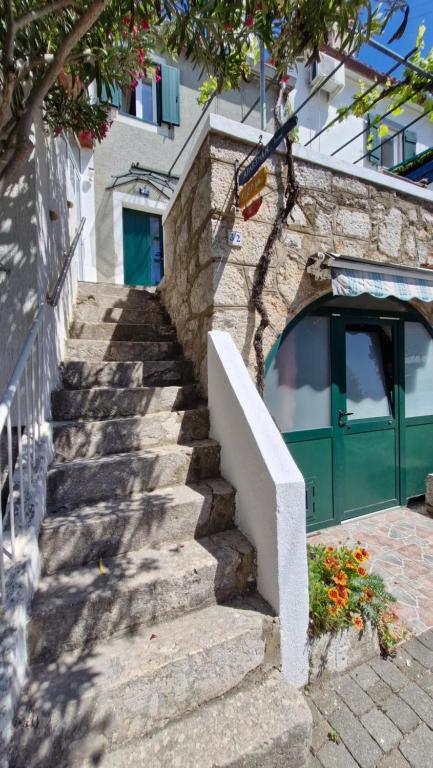 プナトにあるApartman Mocicの緑色のドアのある建物に続く階段