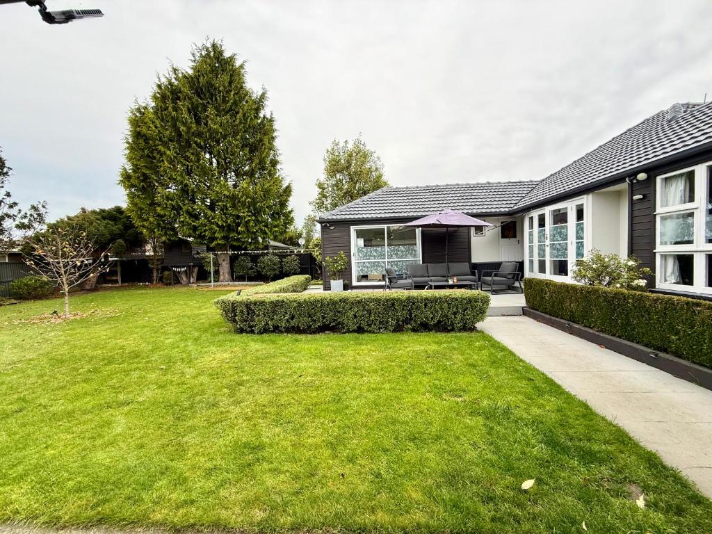 a house with a lawn in front of a house at Cozy and sunny room near City To Seapath in Christchurch