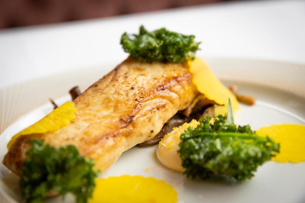 a plate of food with a piece of fish and broccoli at Glenroyal Hotel in Maynooth
