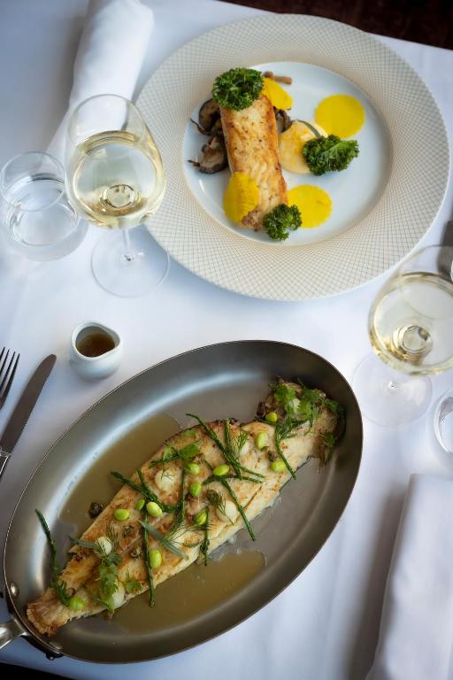 two plates of food on a table with wine glasses at Glenroyal Hotel in Maynooth
