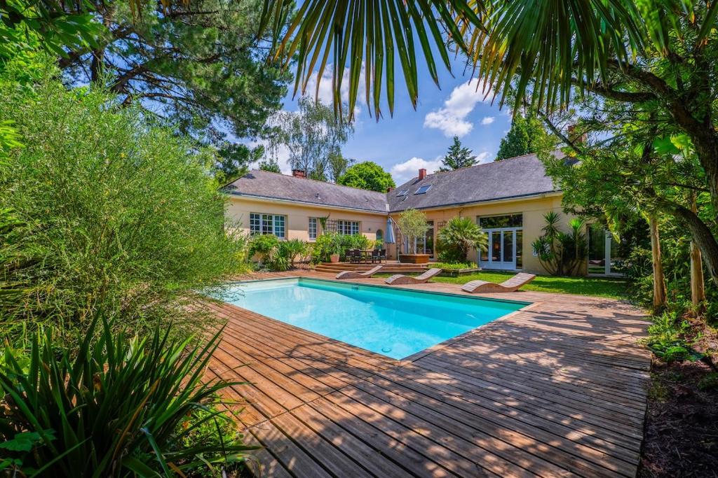 an exterior view of a house with a swimming pool at Villa de La Plume in Nantes