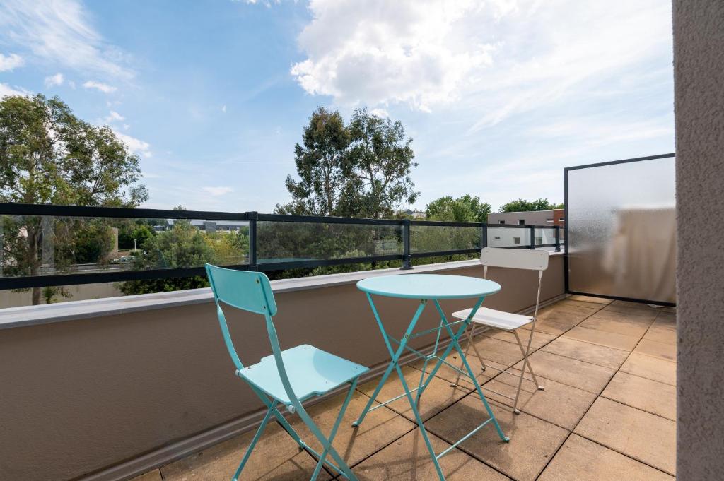 un patio avec une table et des chaises sur un balcon dans l'établissement Studio Proche Port Terrasse et Wifi, à Vannes