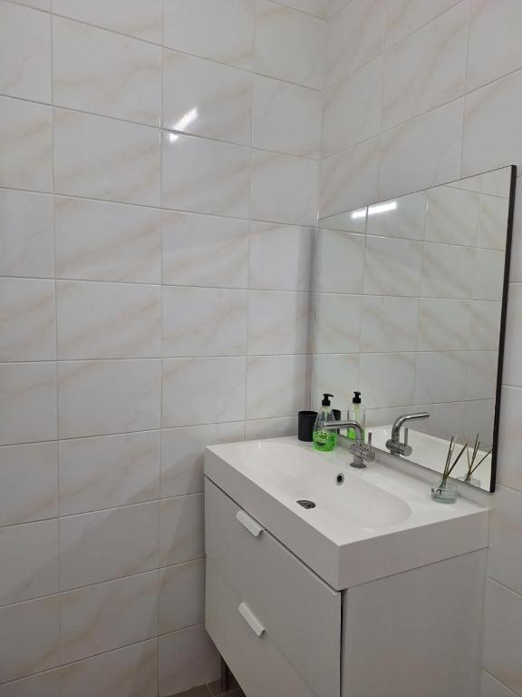 ein weißes Badezimmer mit Waschbecken und Spiegel in der Unterkunft Midi Gateway in Brüssel