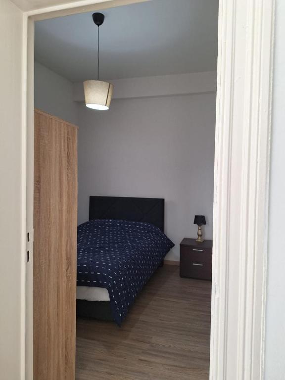 Schlafzimmer mit einem Bett mit blauer Decke in der Unterkunft Midi Gateway in Brüssel