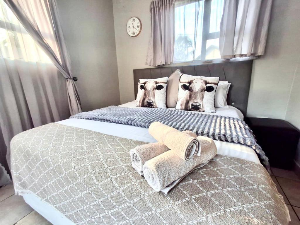 a bedroom with two dogs heads on the bed at OR Tambo Stay Unit 3 in Boksburg