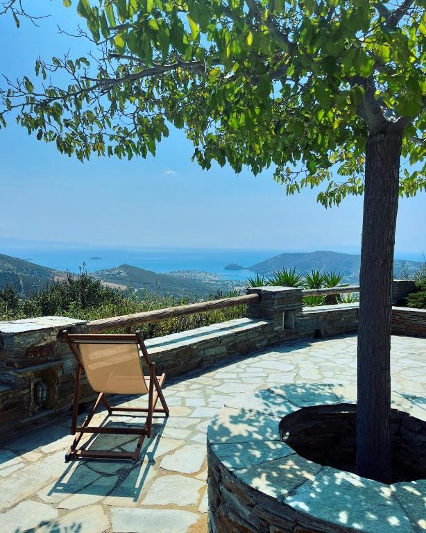 a chair sitting on a patio next to a tree at Anastasia Luxury Villas in Gavrio