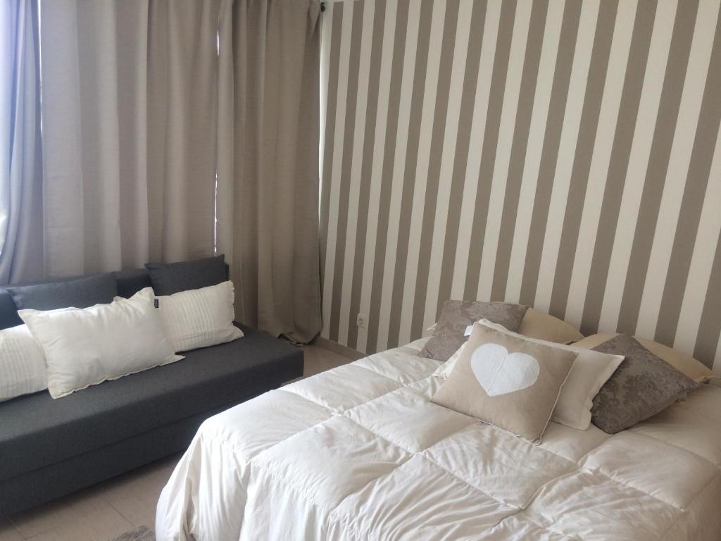 1 dormitorio con cama blanca y sofá en Moura 11, en Vilamoura