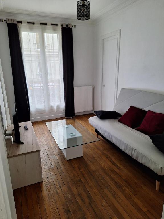 un salon avec un canapé et une table en verre dans l'établissement Charming apartment in the heart of Paris, à Paris