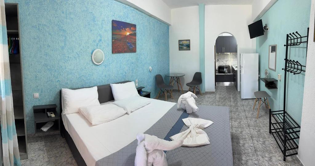 a bedroom with a white bed and a blue wall at Pelagos Beachfront in Panormos Skopelos