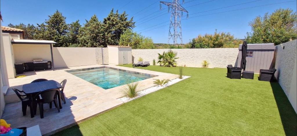 une cour avec une piscine et une pelouse dans l'établissement Maison à louer, à Narbonne