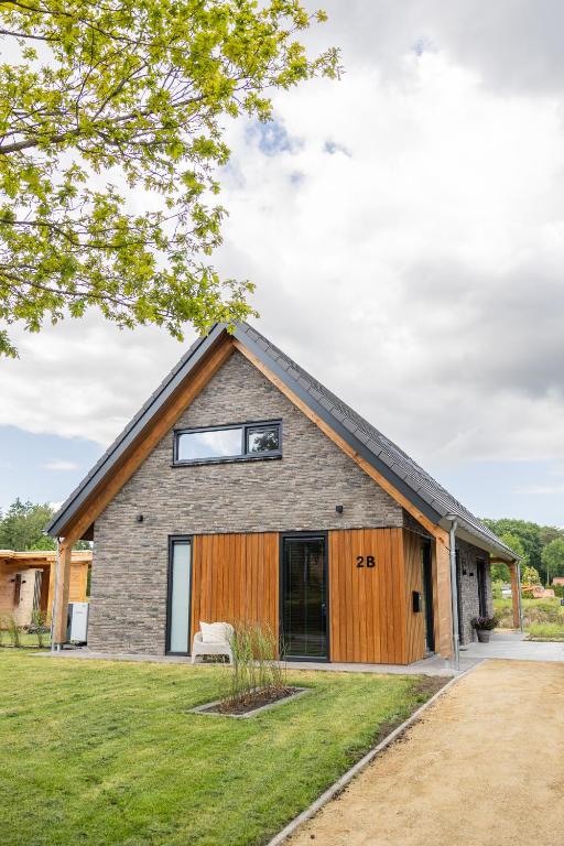 a house with a gambrel roof at Luxe villa aan golfbaan en bosrand in Appelscha in Appelscha