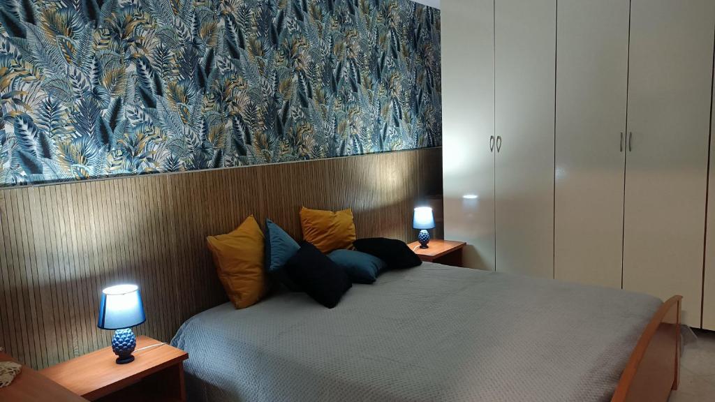 a bedroom with a bed with two lamps on it at Casa Marea in Isola delle Femmine