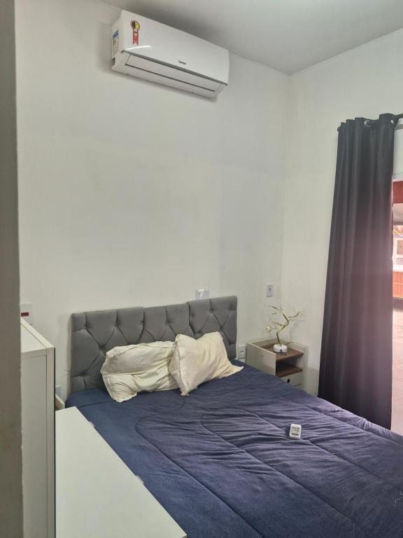 a bedroom with a bed with a blue comforter at Chacara cad club quarto de casal in Sao Jose do Rio Preto