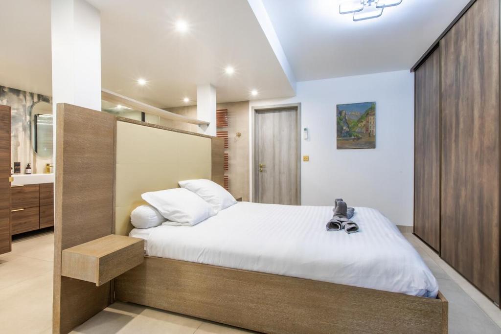une chambre avec un grand lit avec des draps blancs dans l'établissement Appartement en bord de mer avec piscine - Cannes, à Cannes
