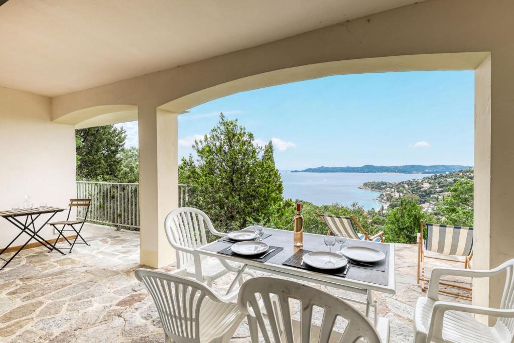 une table et des chaises sur une terrasse avec vue sur l'océan dans l'établissement Bright apartment with terrace and sea view Le Lavandou, au Lavandou