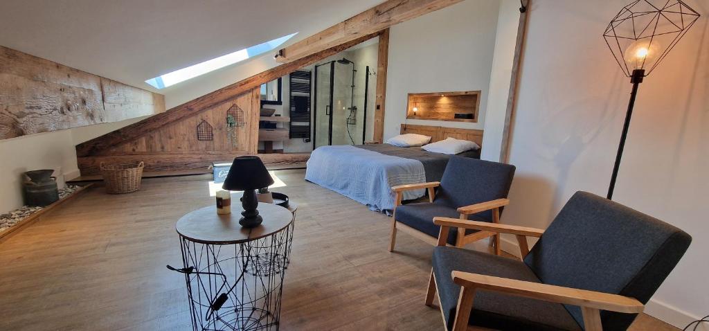 une chambre avec un lit, une table et des chaises dans l'établissement Le cosy du Théâtre, duplex confortable au centre de Chambéry, à Chambéry