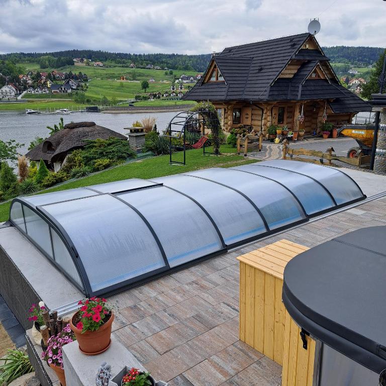 a greenhouse on a patio with a house at Gazdówka in Gródek Nad Dunajcem