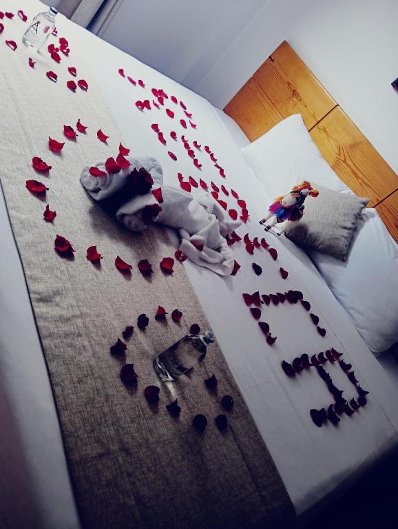 a bed with red rose petals on it at Fenix Machupicchu in Machu Picchu