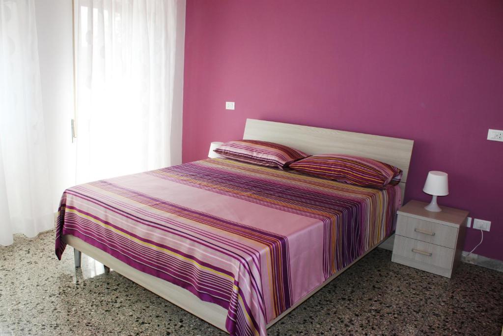 una camera con un letto con una parete viola di B&B Street Art Roma a Roma