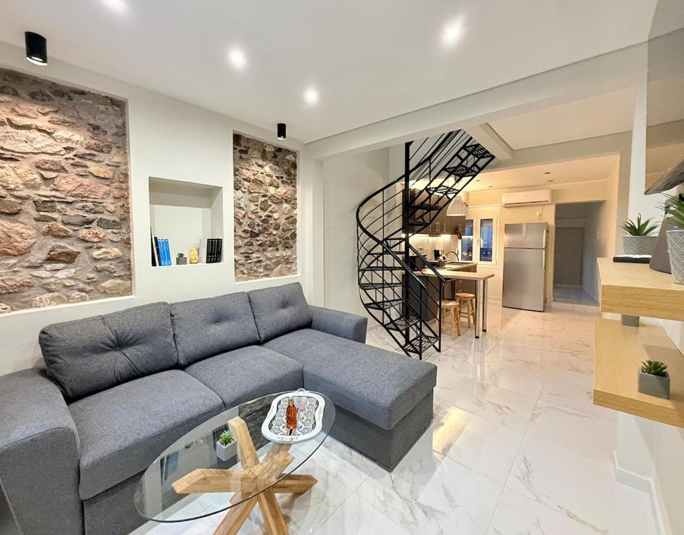 a living room with a blue couch and a staircase at Cozy Mytilene Downtown in Mytilini