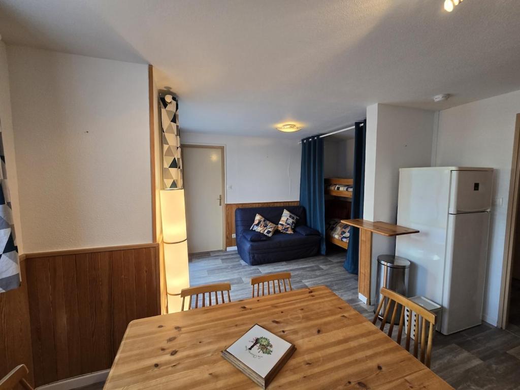 une cuisine et une salle à manger avec une table et un réfrigérateur dans l'établissement Les Bartavelles, à Allemont