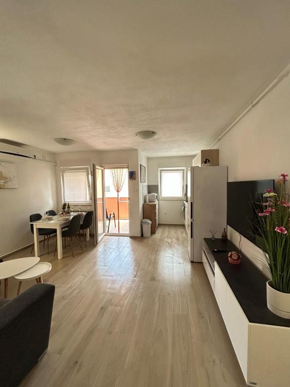 a large living room with a table and a refrigerator at Apartman Romina in Pula
