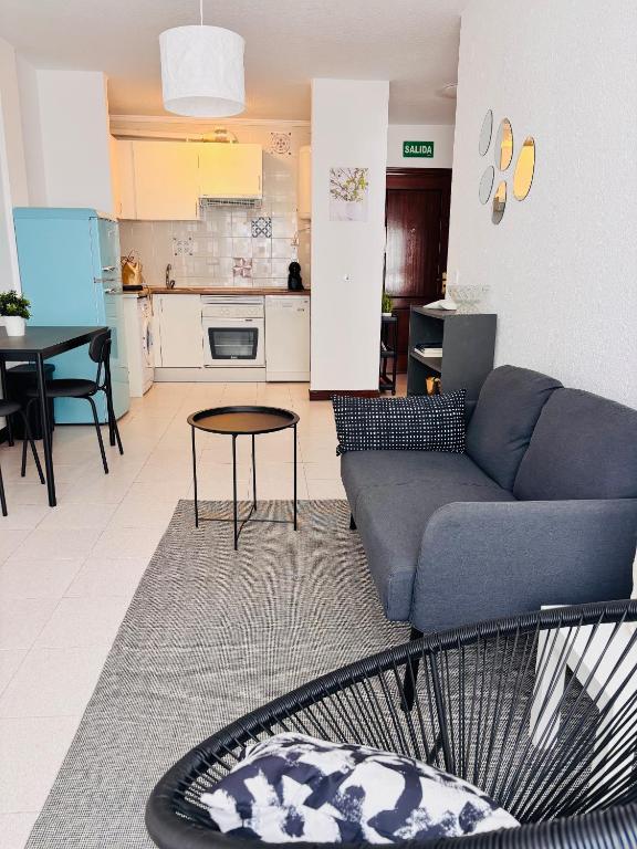 a living room with a couch and a kitchen at VerdeAgua Cantabria con Piscina in Ajo