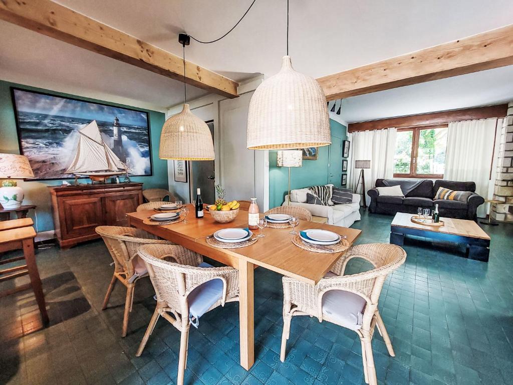 un salon avec une table et des chaises en bois dans l'établissement Holiday Home Villa Salut l'Artiste by Interhome, à Les Sables-dʼOlonne