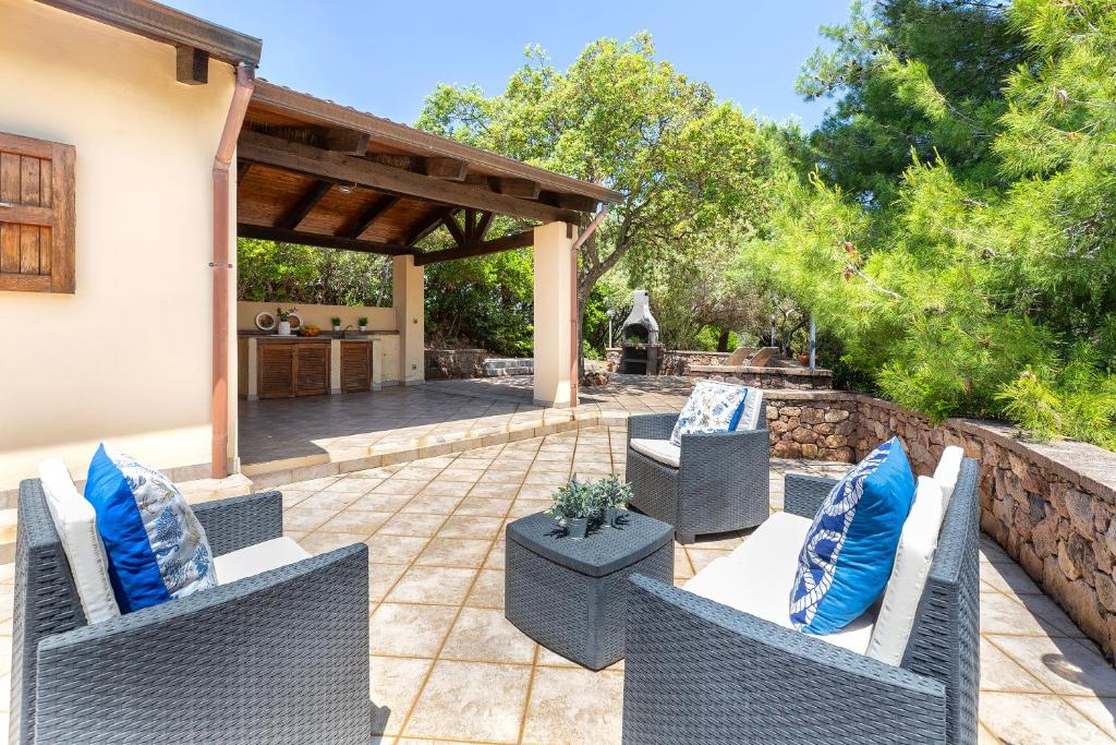 アルゲーロにあるSARDINIA RE - Villa Green Valのパティオ(椅子2脚、テーブル、青い枕付)