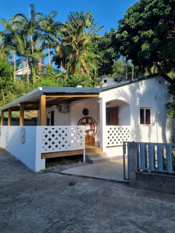 a white house with a gate and a fence at Chez Jacques in Sainte-Clotilde