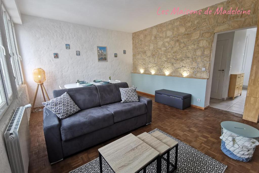 un salon avec un canapé et une table dans l'établissement Le Robinson - Les Maisons de Madeleine, à Nantes