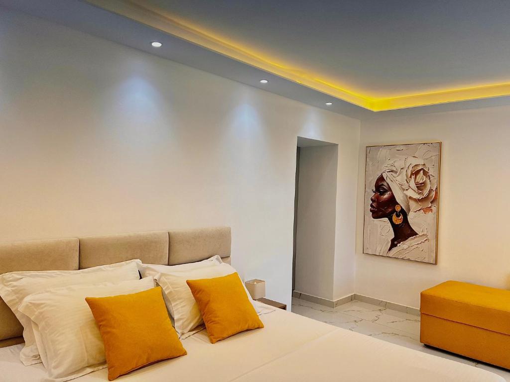 a bedroom with a bed with orange and white pillows at Dine Hotel in Ksamil