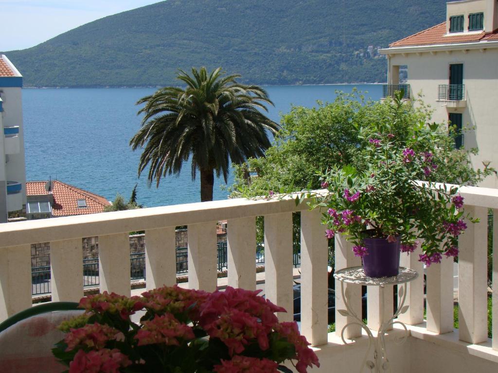 un balcón con flores y vistas al agua en Apartments Milicevic, en Herceg-Novi