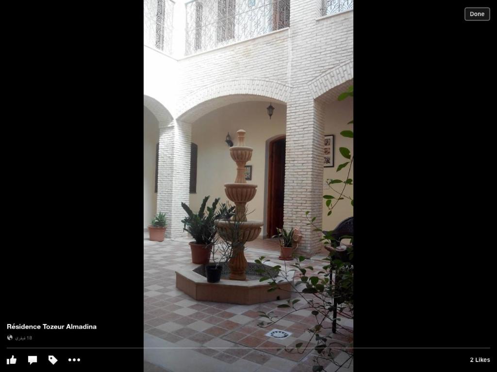 a courtyard with potted plants in a building at Residence Tozeur Almadina in Tozeur