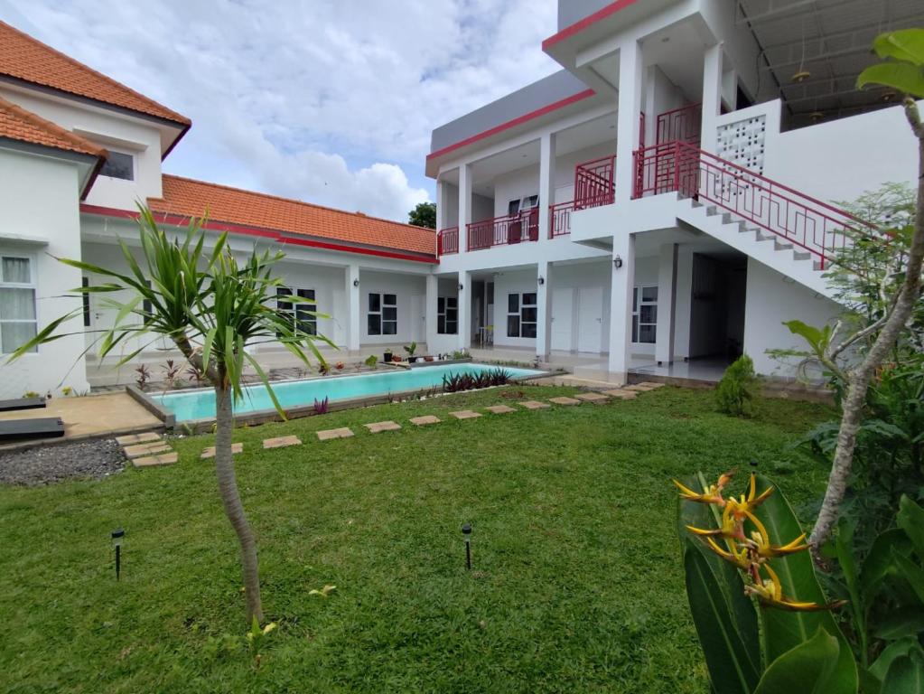 a villa with a swimming pool and a yard at Menepi Bali in Uluwatu