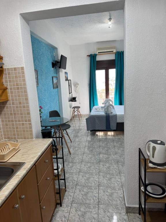 a room with a kitchen and a bedroom with a bed at Pelagos Beachfront in Panormos Skopelos