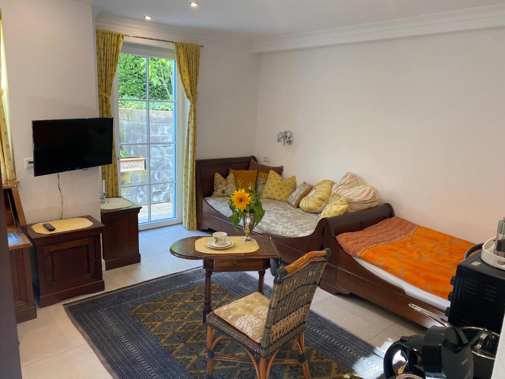 a bedroom with a bed and a table and a tv at Charmantes Einzelzimmer in Odenthal